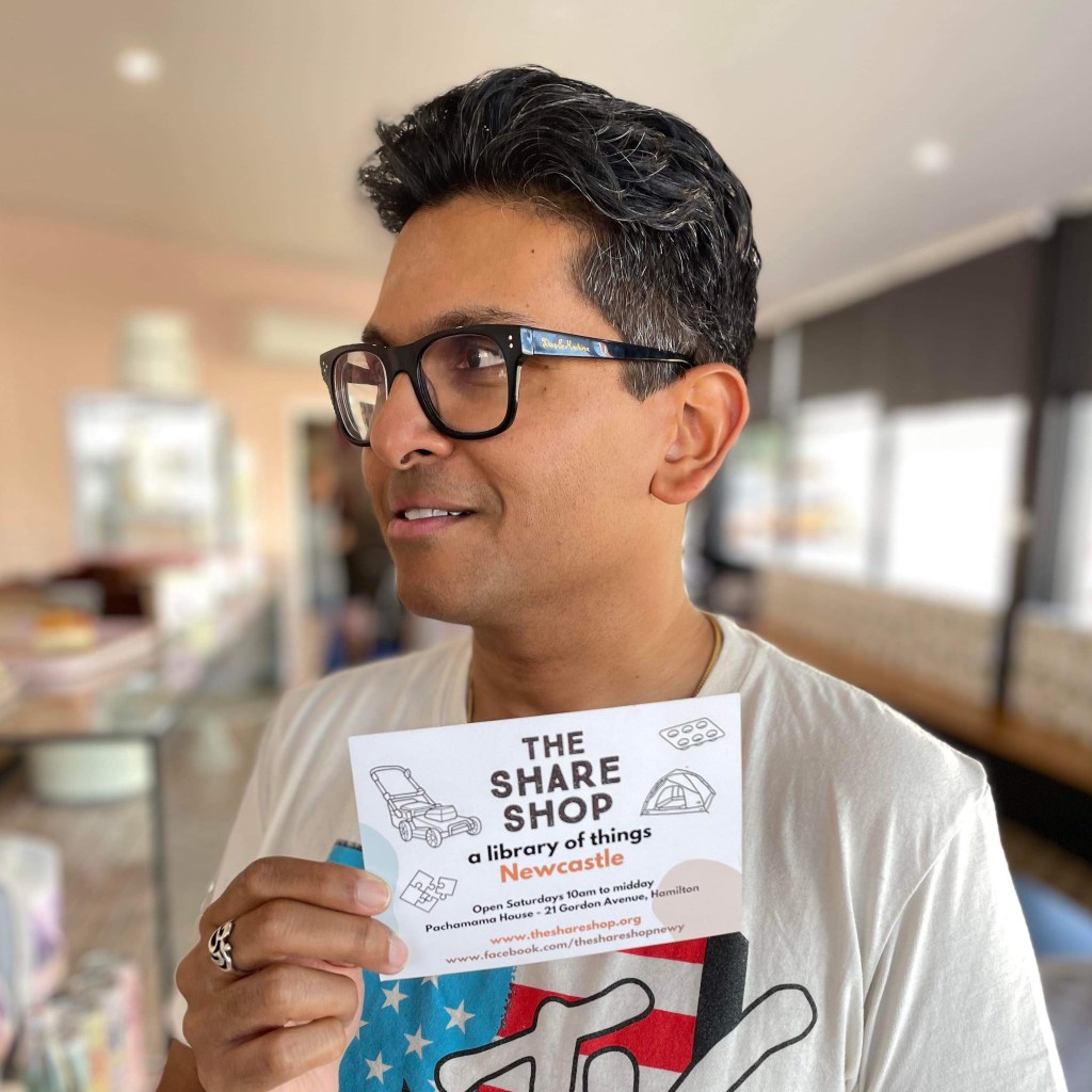A supporter of The Share Shop holding up a postcard promoting the organisation